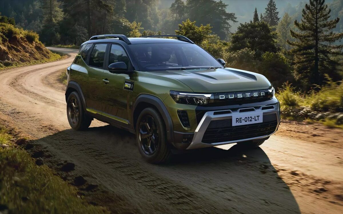 A green Renault Duster driving on a dirt road through a pine forest