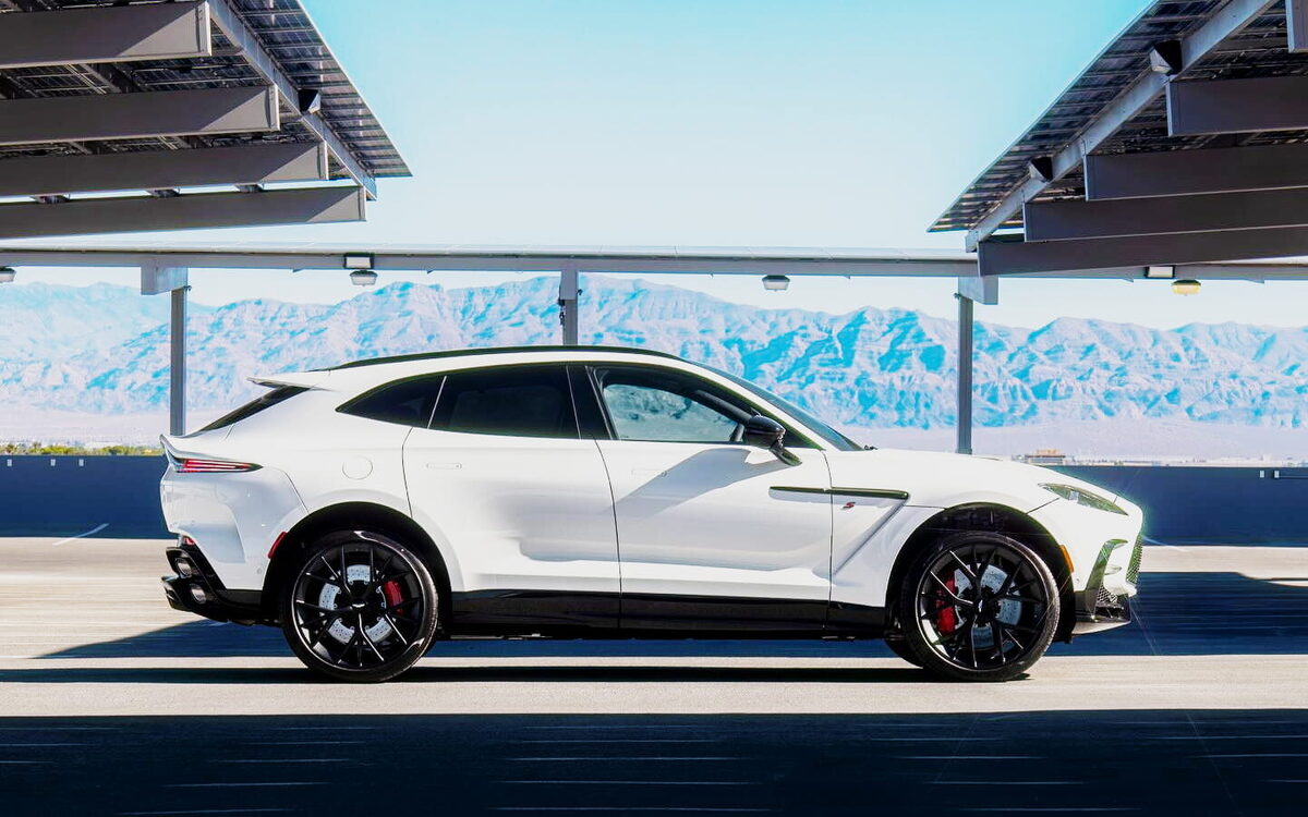 White Aston Martin DBX S in side profile under a solar canopy