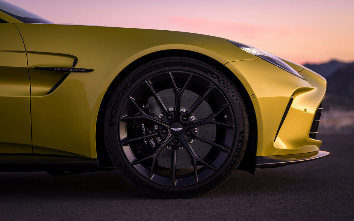 Yellow Aston Martin Vantage front wing and black alloy wheel at dusk