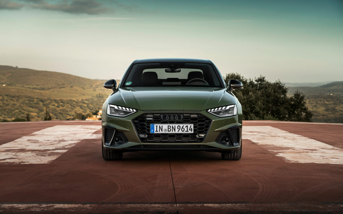 Audi A4 in District Green seen head-on showing the grille and LED headlamps