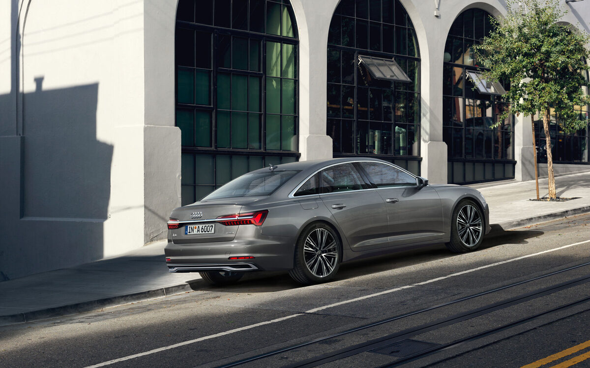 Audi A6 in Chronos Grey, rear three-quarter view on a city street