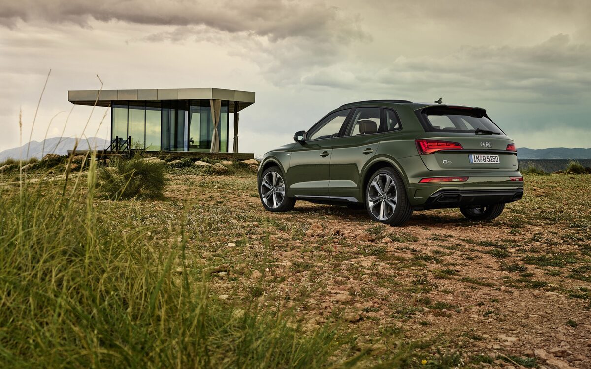 Audi Q5 in District Green, rear three-quarter view showing the LED tail lamps and tailgate