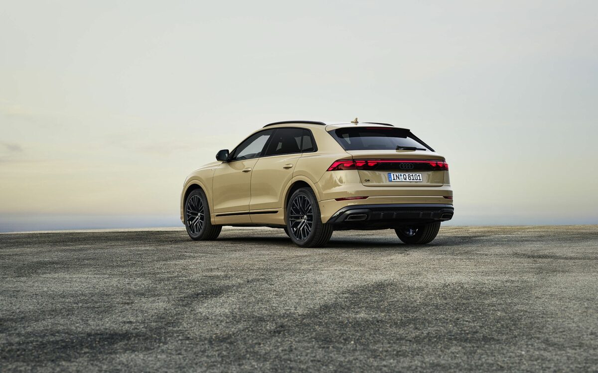 Audi Q8 in Sakhir Gold, rear three-quarter view showing the light bar and twin exhaust tips