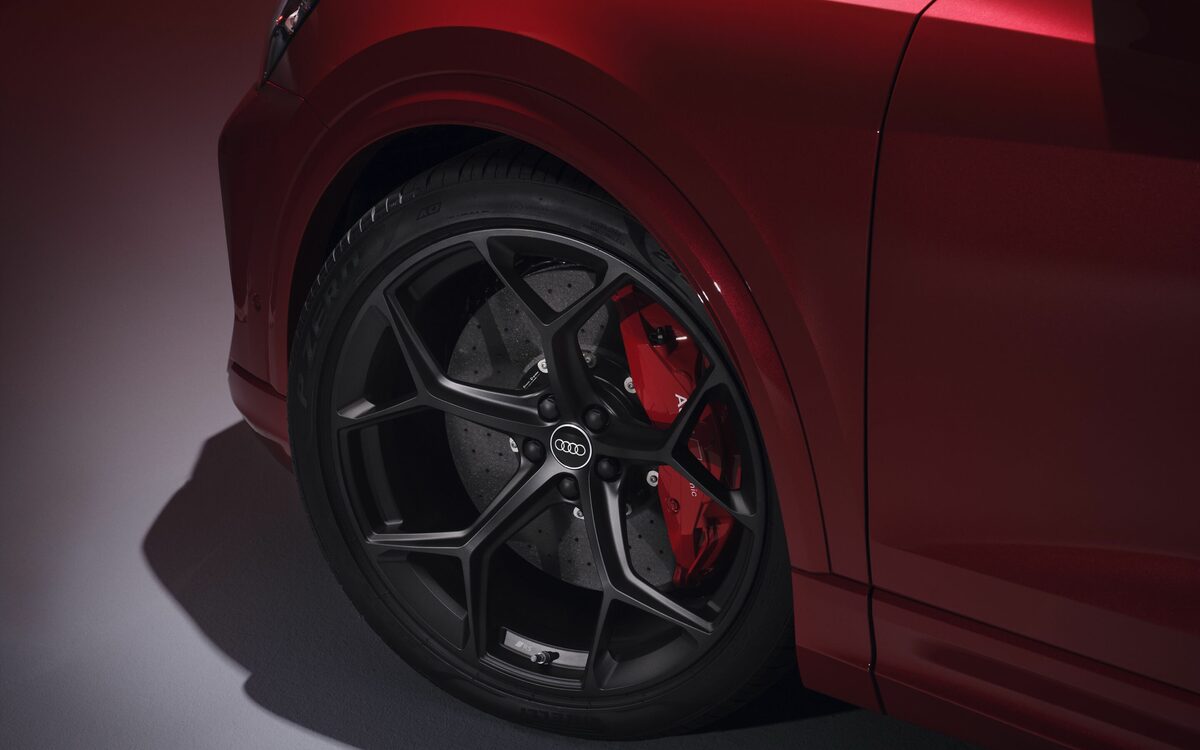 Audi RS Q8 performance in Chili Red, alloy wheel with red brake caliper in a studio