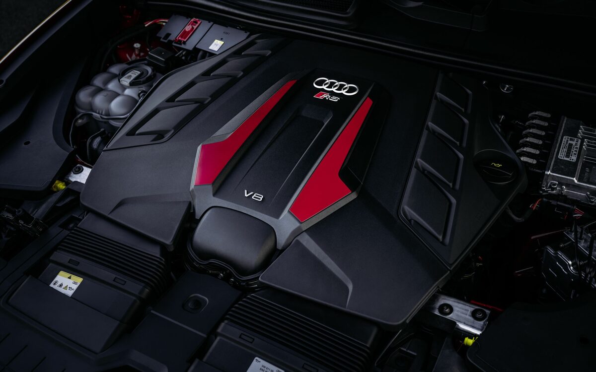 Audi RS Q8 performance in Chili Red, V8 engine cover with RS logo under the bonnet