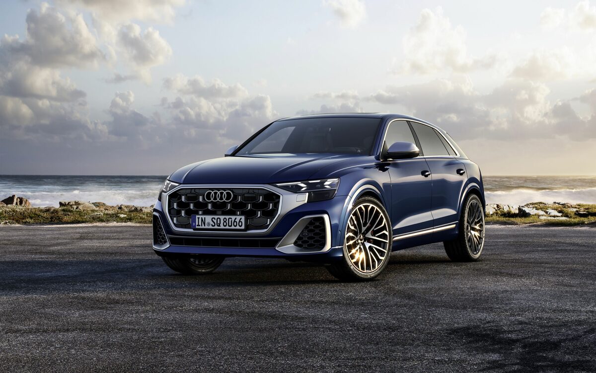Audi SQ8 in Waitomo Blue, front three-quarter view parked on a coastal tarmac pad