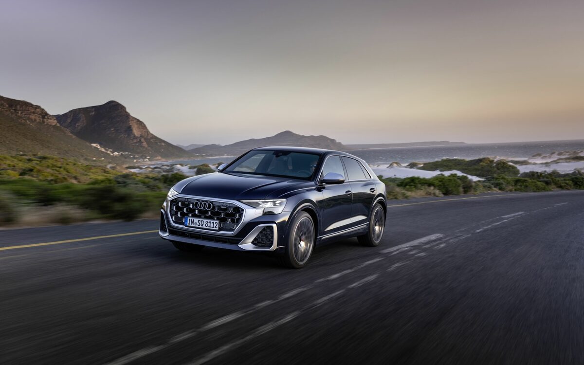 Audi SQ8 in Waitomo Blue, front three-quarter view driving along a coastal road