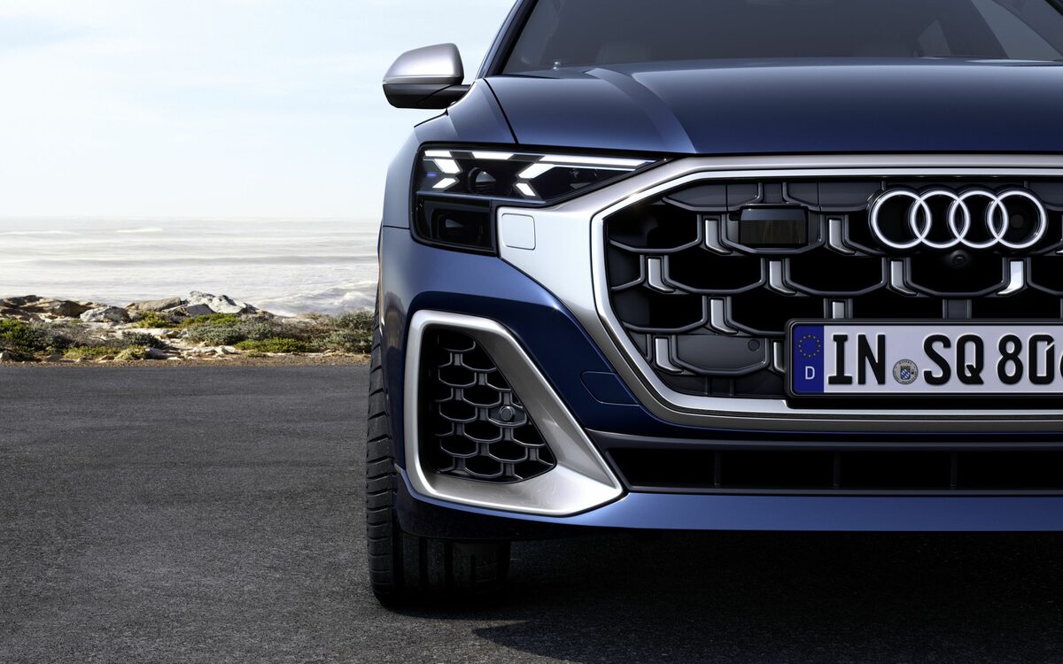 Audi SQ8 in Waitomo Blue, close-up of the honeycomb grille, headlamp and silver bumper trim