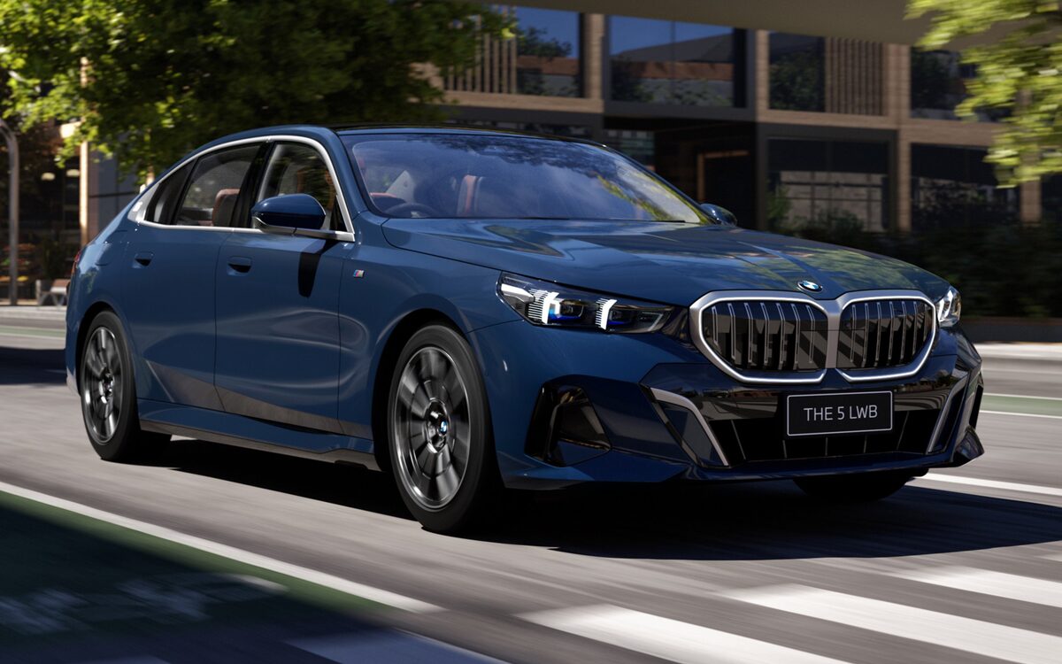 BMW 5 Series Long Wheelbase in blue, front three-quarter view driving on a city street