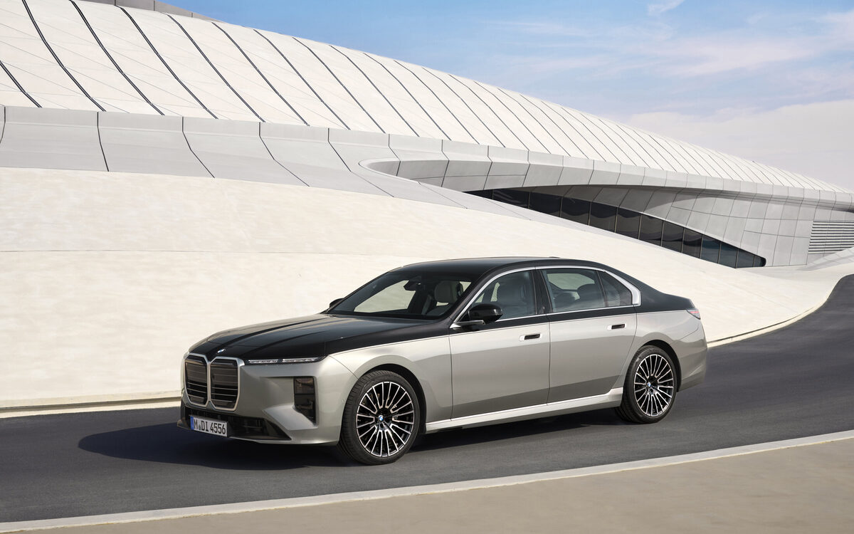 BMW 7 Series in a dual-tone finish, front three-quarter view on a curving road