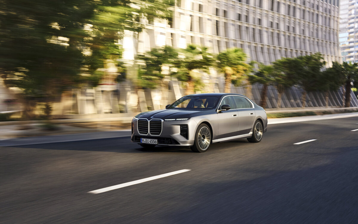BMW 7 Series driving along a tree-lined city road