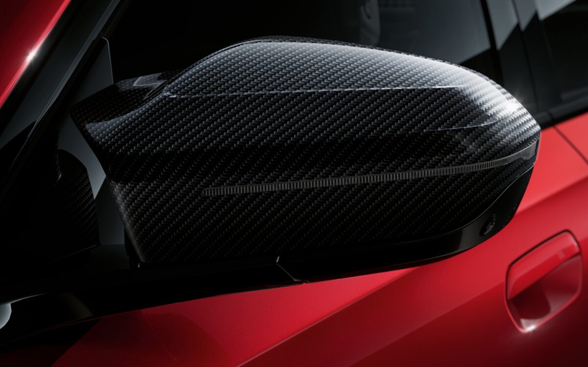 Carbon-fibre mirror cap on the red BMW i5 M60