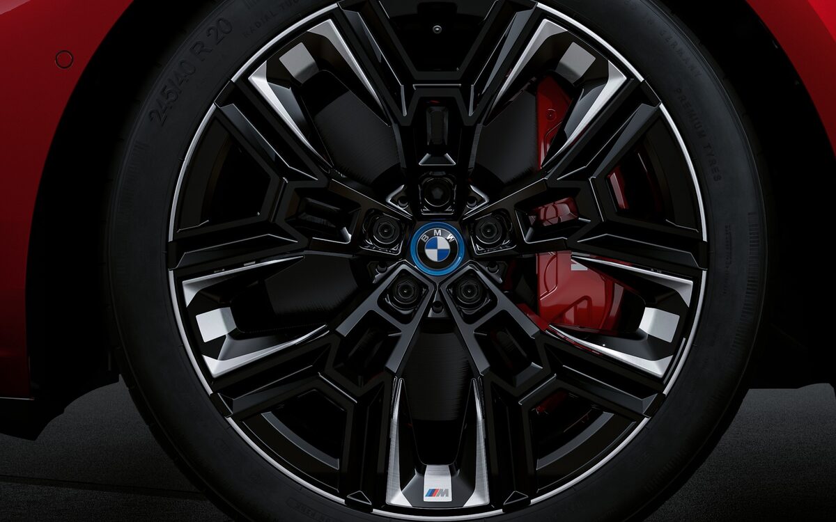 Close-up of the black alloy wheel with red M sport brake caliper on the BMW i5 M60