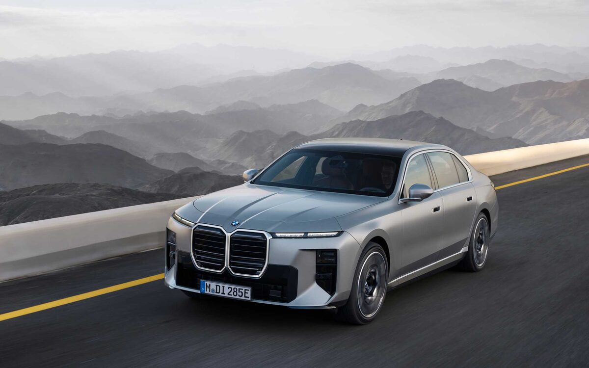 BMW i7 in silver driving on a mountain road, front three-quarter view