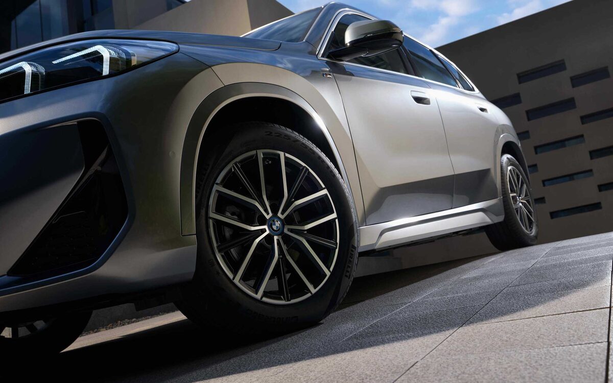 Low close-up of the iX1 LWB alloy wheel and front wing