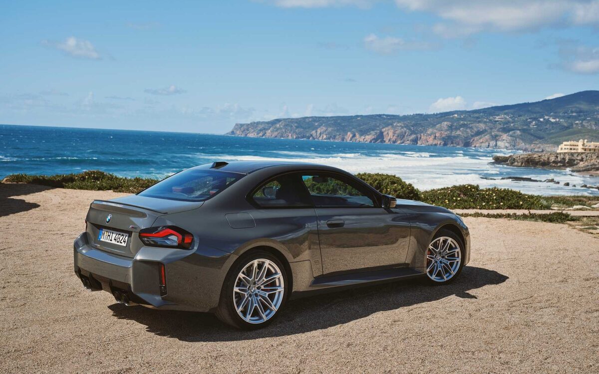BMW M2 in grey, rear three-quarter view on a coastal viewpoint