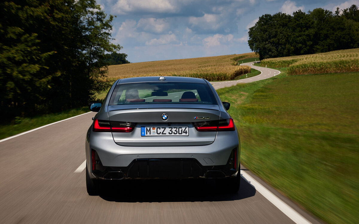 BMW M340i xDrive driving away on a country road, seen from behind