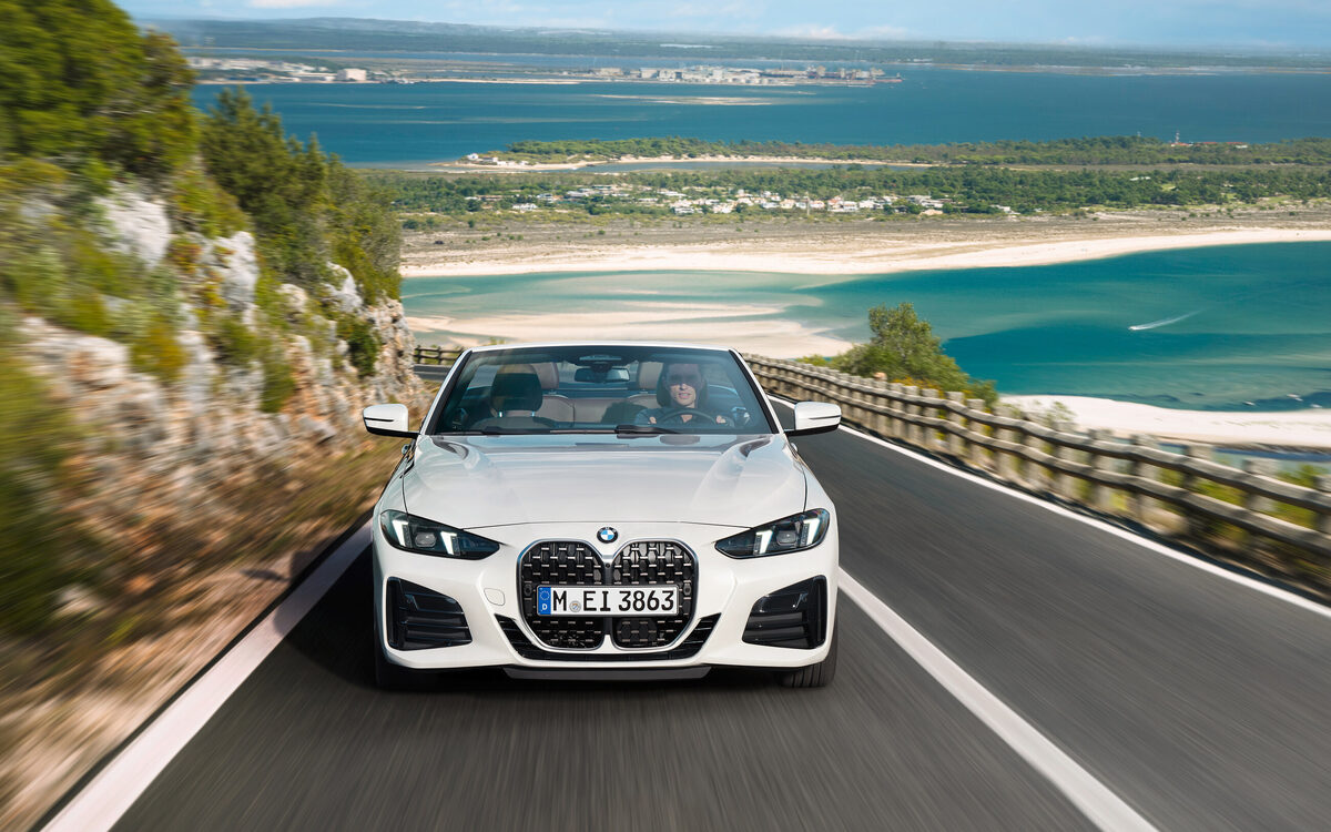 BMW 4 Series Convertible driving on a coastal road, front view