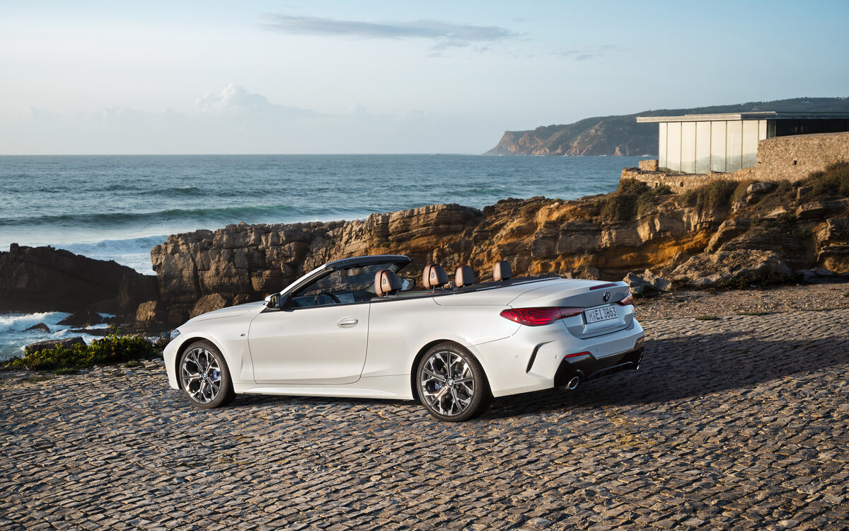 BMW 4 Series Convertible parked by the sea, rear three-quarter view