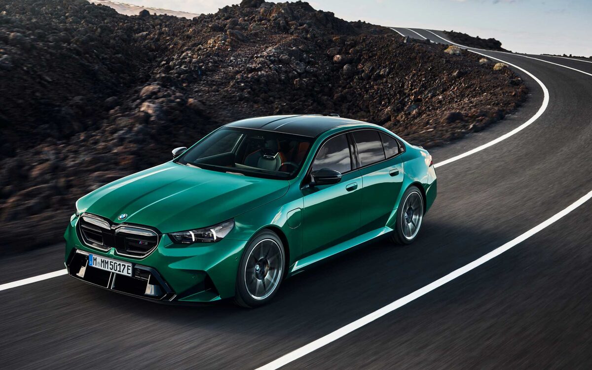 BMW M5 in M Isle of Man Green on a mountain road, front three-quarter view