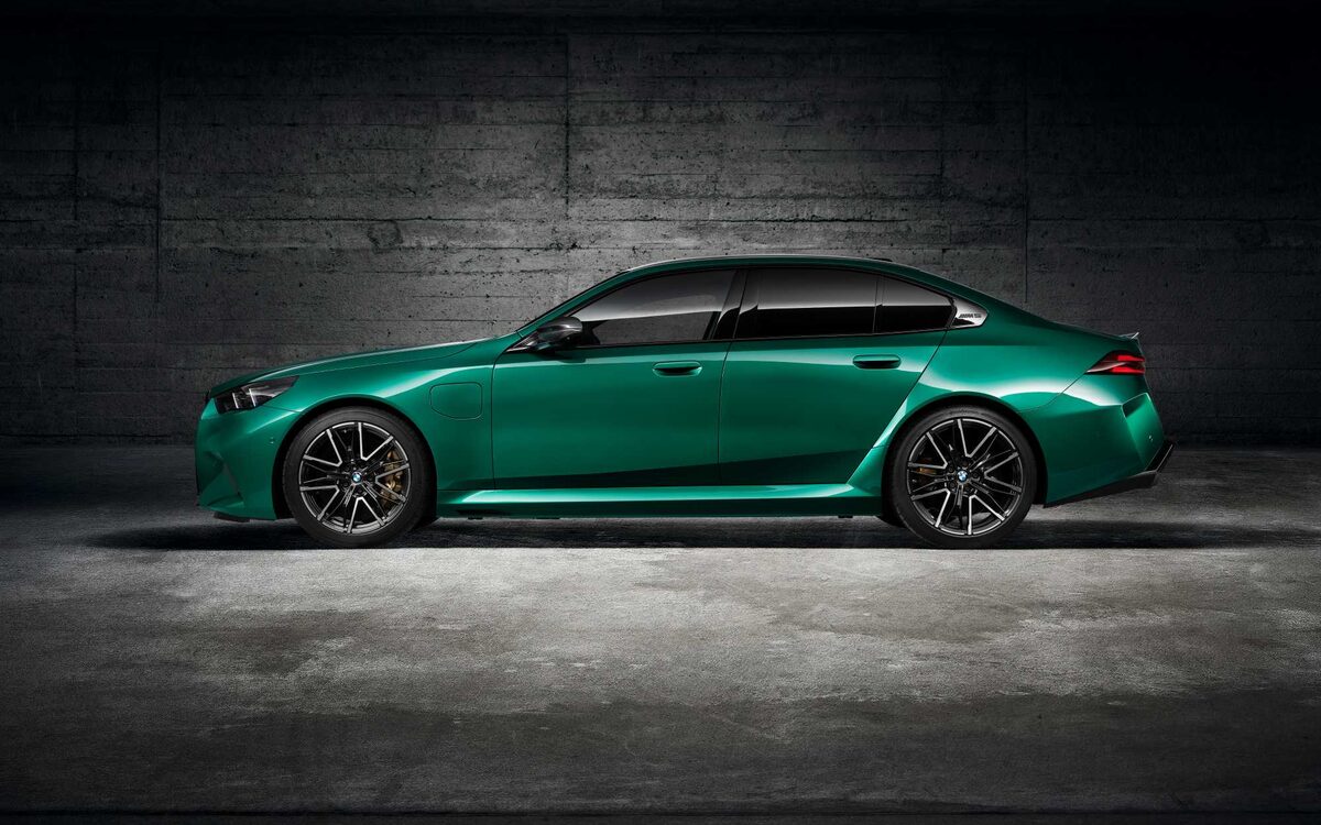 BMW M5 in green photographed in a studio, side profile