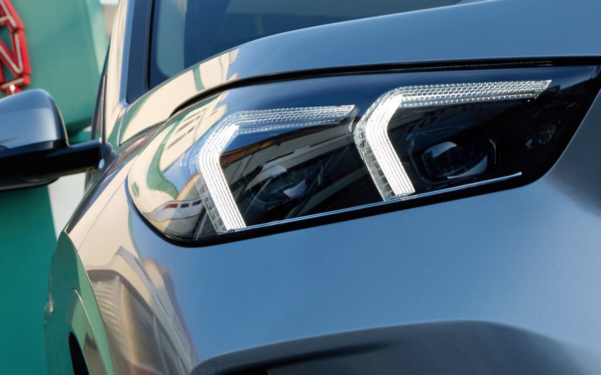Close-up of the slim LED headlamp with L-shaped daytime running light on the BMW X1 LWB