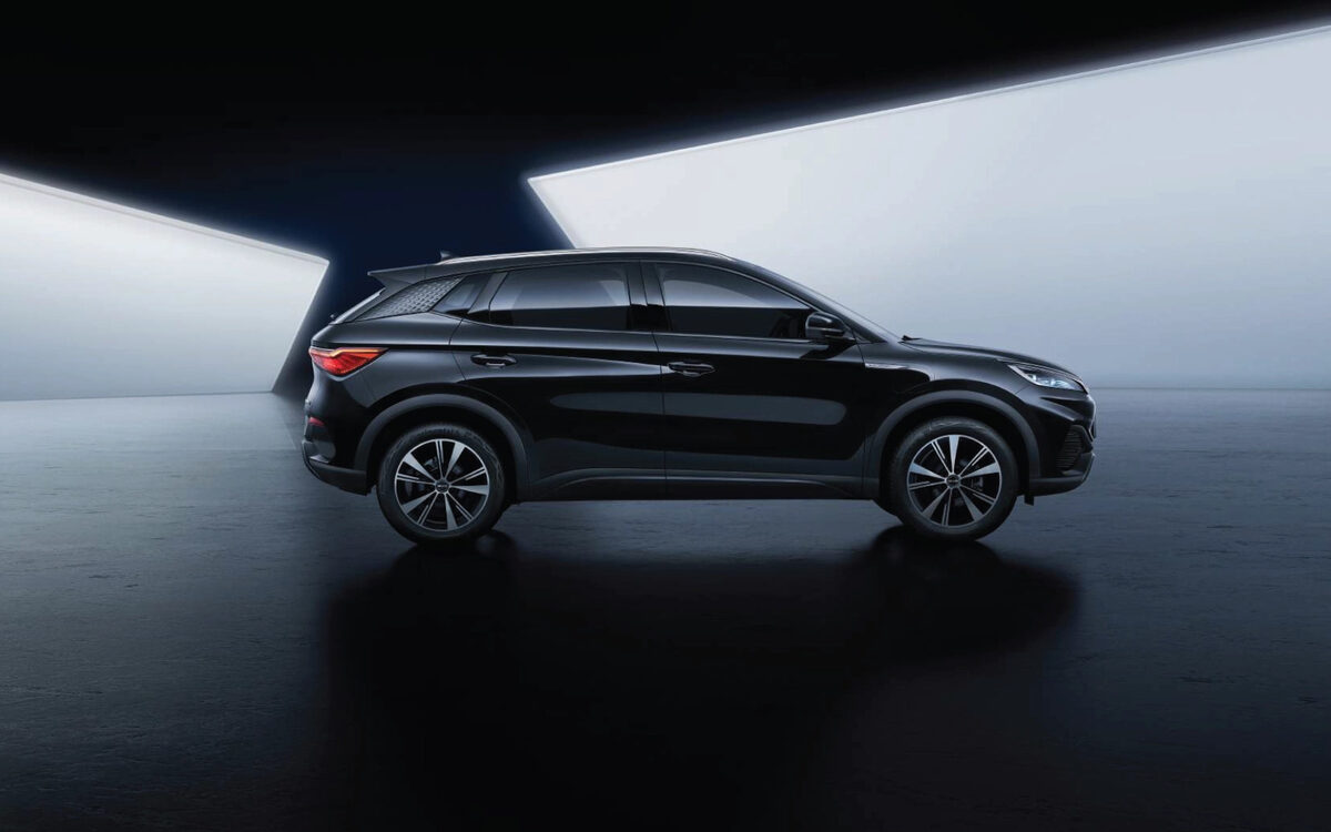 BYD Atto 3 in black, side profile in a dark studio with a bright light panel