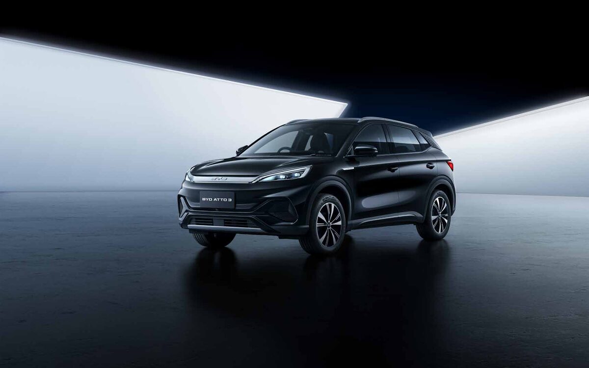 BYD Atto 3 in black, front view in a dark studio with a bright light panel behind