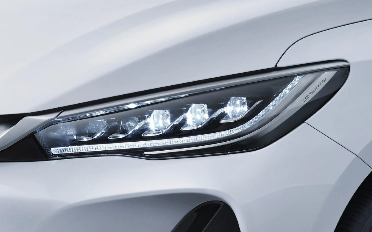 BYD eMAX 7 in white, close-up of the LED headlamp with its row of lens elements