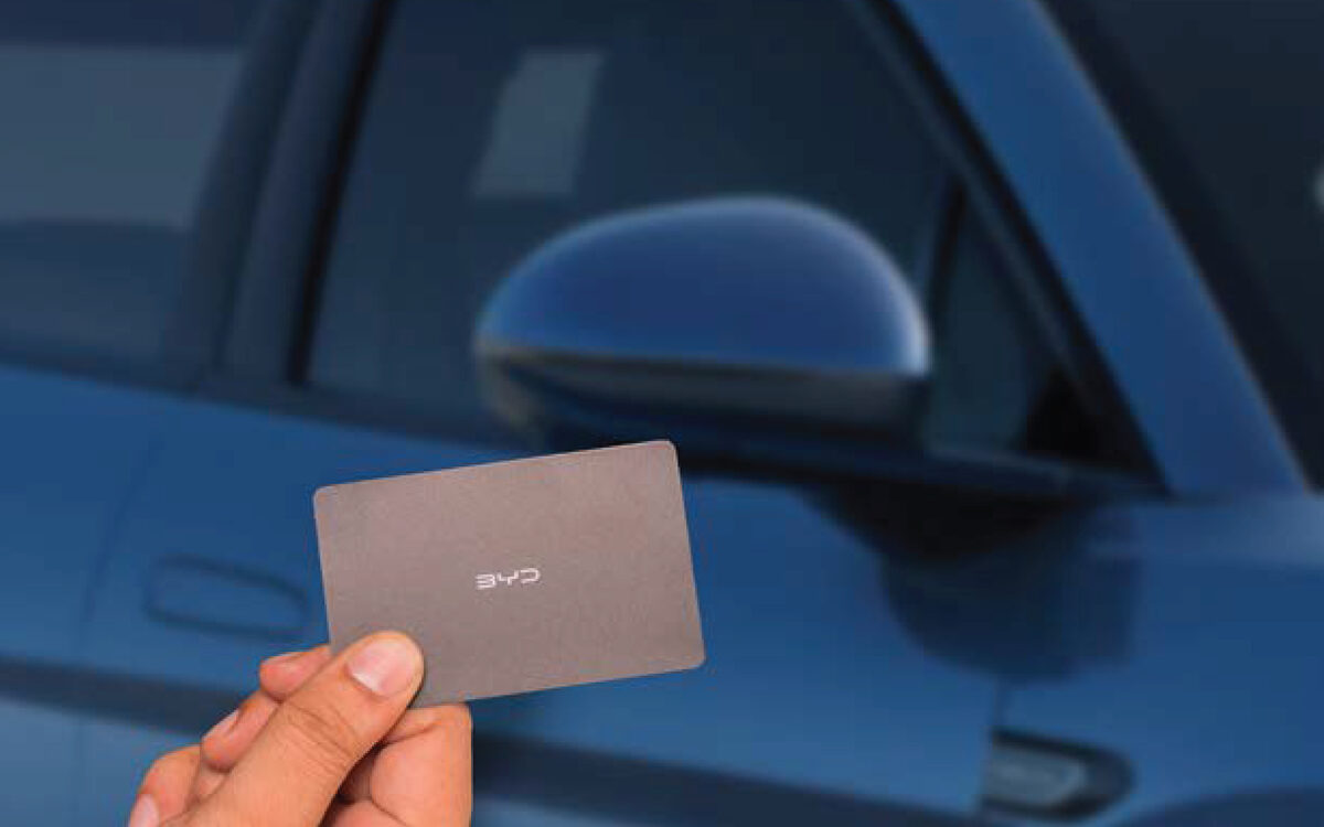 Hand holding the BYD NFC card key against the door mirror area of the Sealion 7