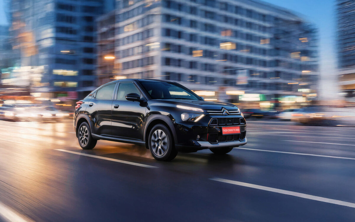 Citroen Basalt in black, front three-quarter view driving on a city road at dusk