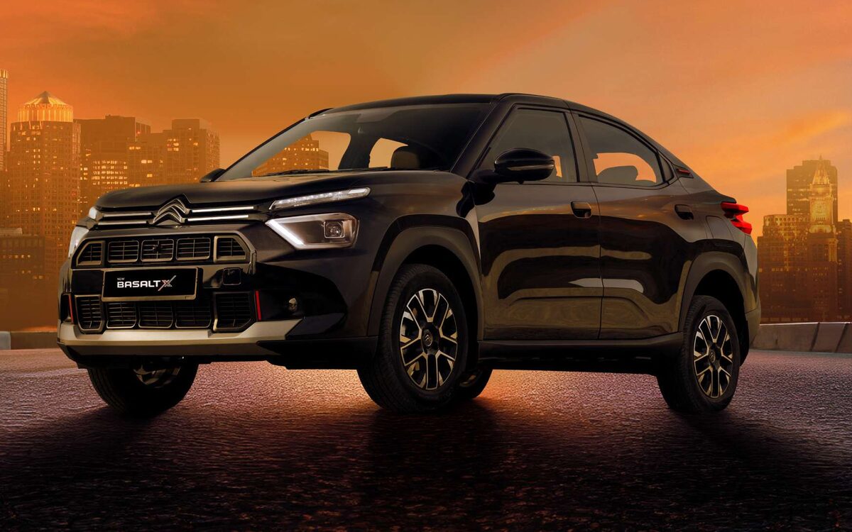Citroen Basalt in black, low front view on a road under an orange sunset sky