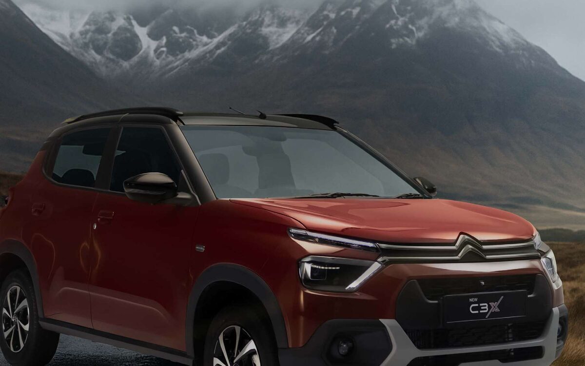Citroen C3 in red parked in front of misty snow-capped mountains