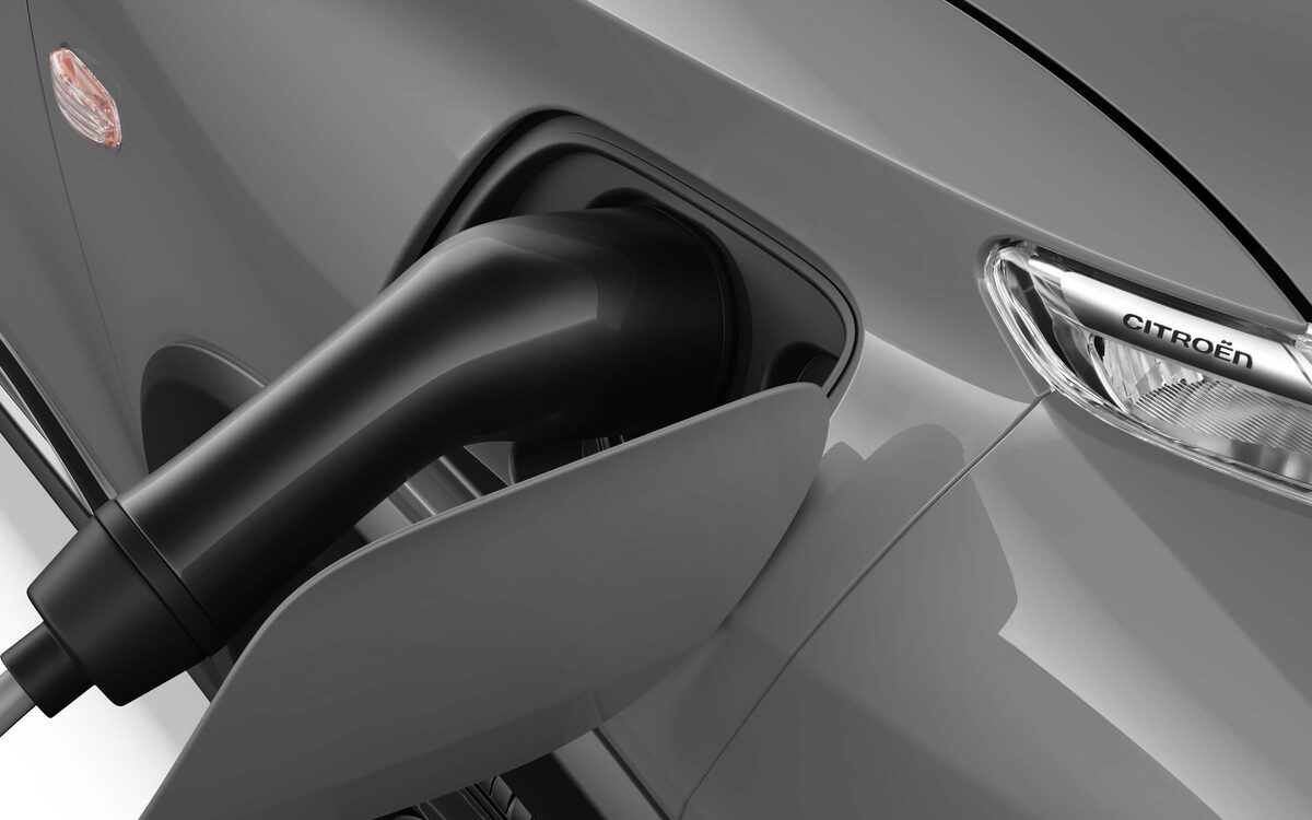 Charging plug inserted in the charge port of the Citroen eC3 beside the headlamp