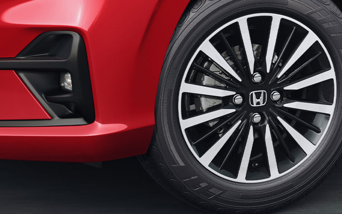 Close-up of the Honda Amaze alloy wheel and front fog lamp area on a red car
