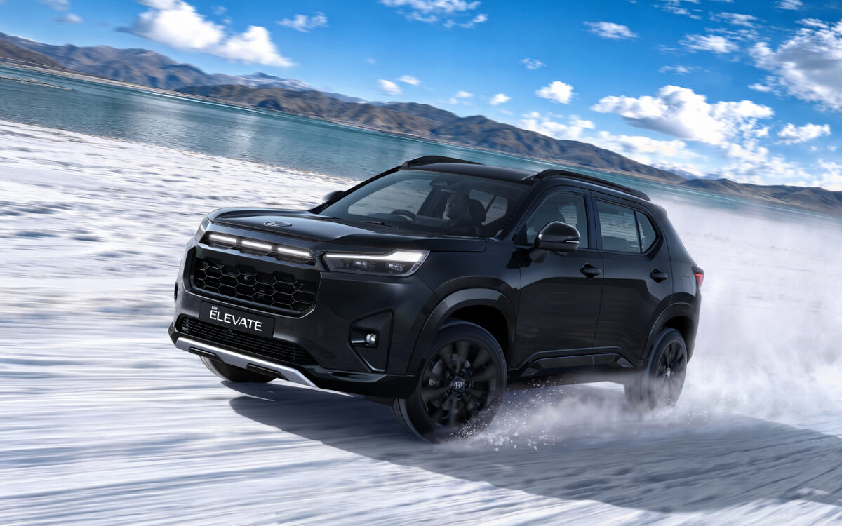 Honda Elevate in black with black alloy wheels, front three-quarter view driving through snow beside a mountain lake