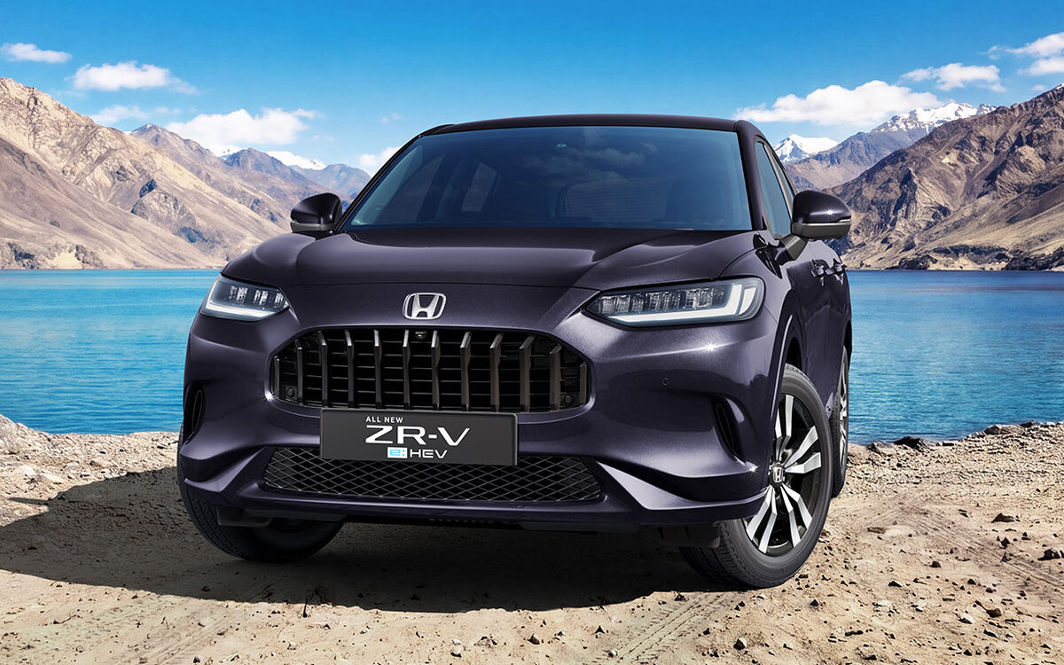 Honda ZR-V e:HEV in Twilight Mist Black Pearl seen head-on beside a mountain lake