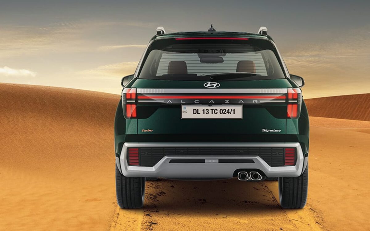 Hyundai Alcazar in black seen from directly behind on a desert track