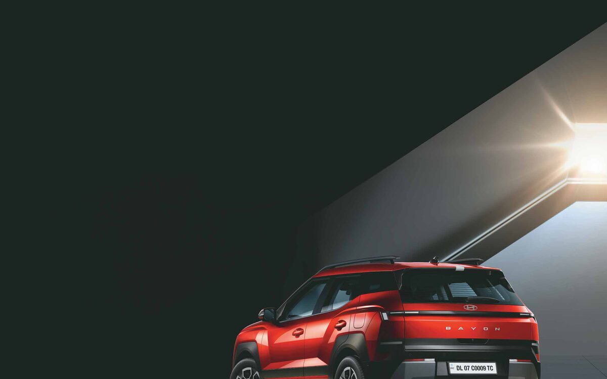 Hyundai Bayon rear three-quarter in Fiery Red under dramatic lighting