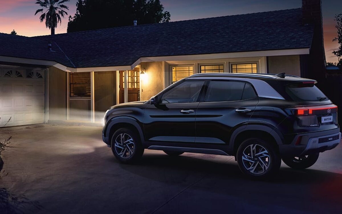 Hyundai Creta in black parked outside a house at dusk with its headlamps and tail lamps lit