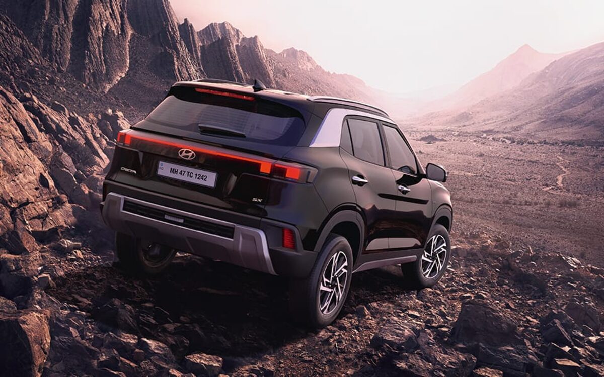 Hyundai Creta in black seen from the rear three-quarter on a rocky mountain trail