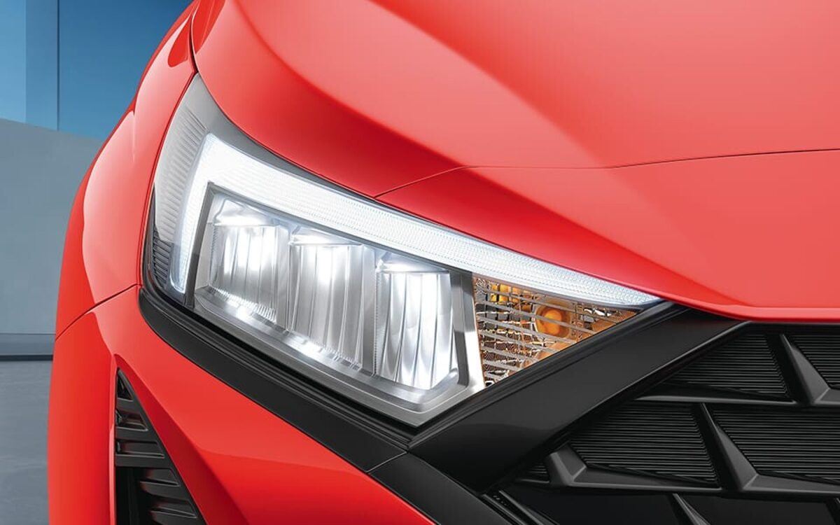 Close-up of the Hyundai i20's LED headlamp and grille on a red body
