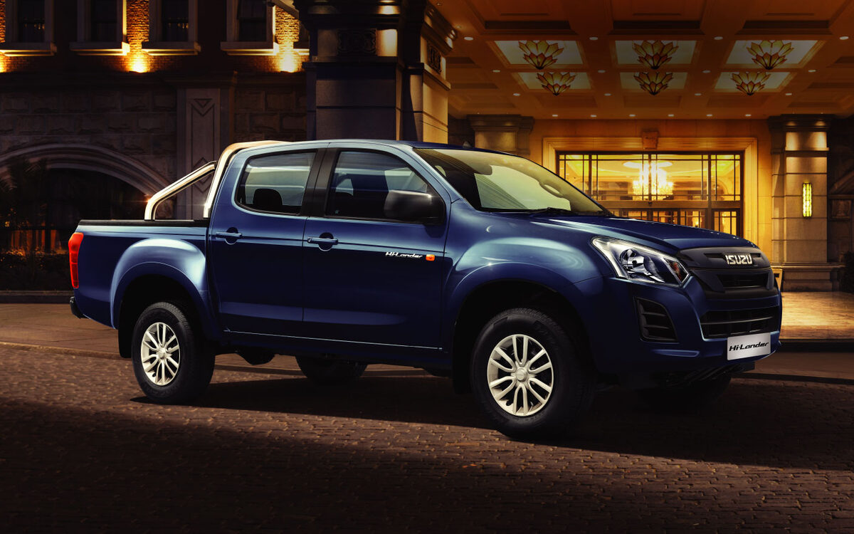 Blue Isuzu Hi-Lander parked outside a lit building entrance at night, side and front view