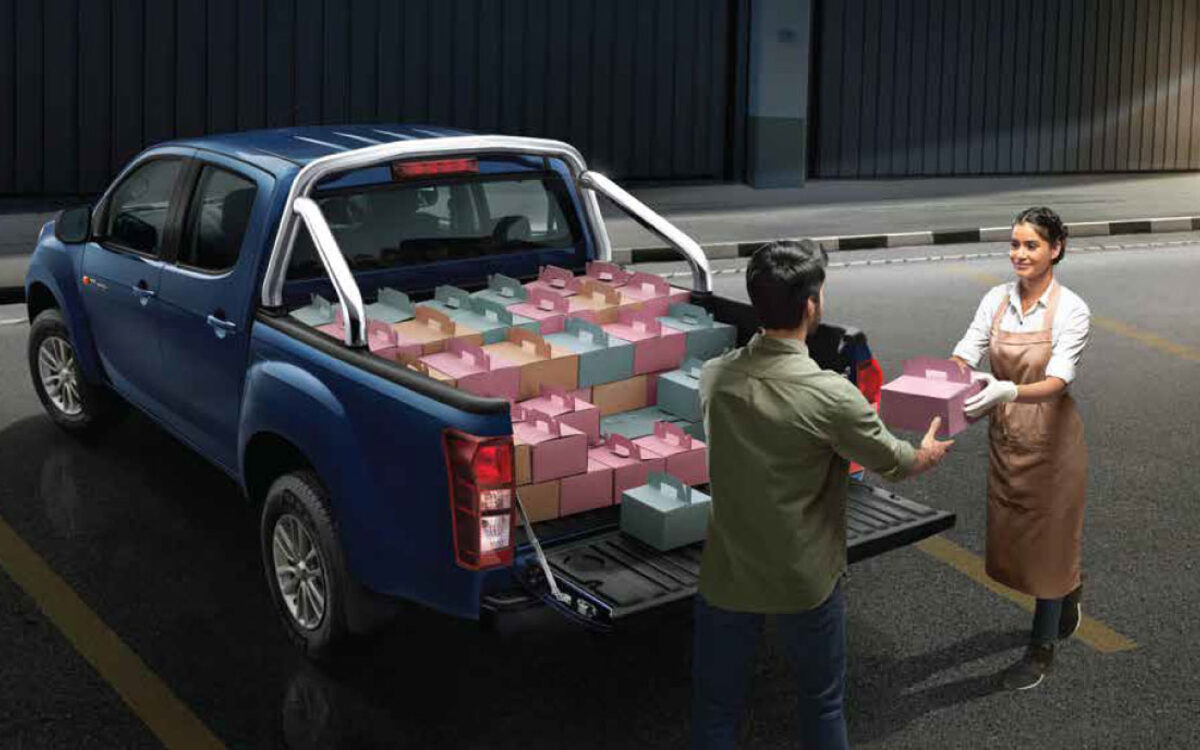 Blue Isuzu Hi-Lander with its load bed full of boxes being unloaded on a street