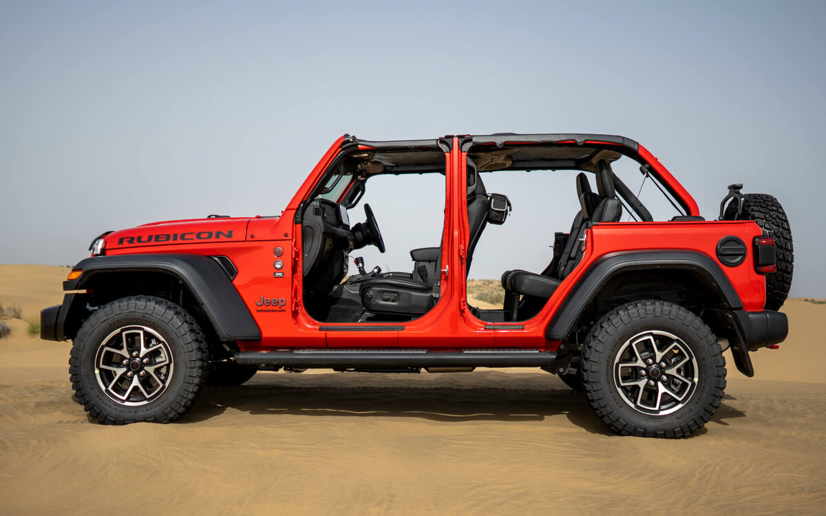 Jeep Wrangler Rubicon in Firecracker Red, side profile in the desert with doors off