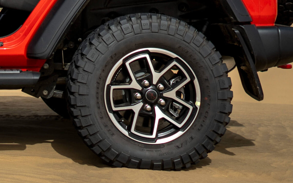 Close-up of the Wrangler Rubicon alloy wheel and off-road tyre on sand