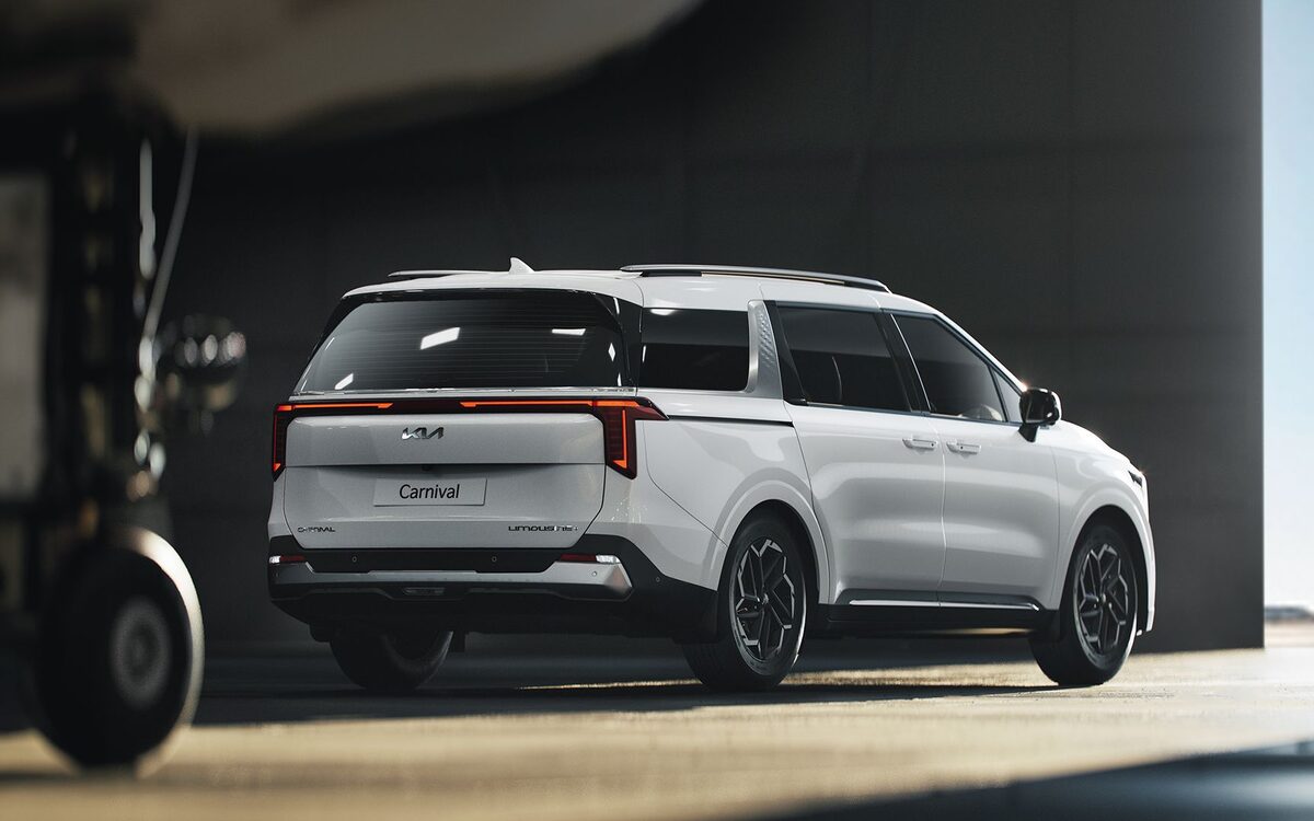 Kia Carnival in white, rear three-quarter view with LED tail lamps
