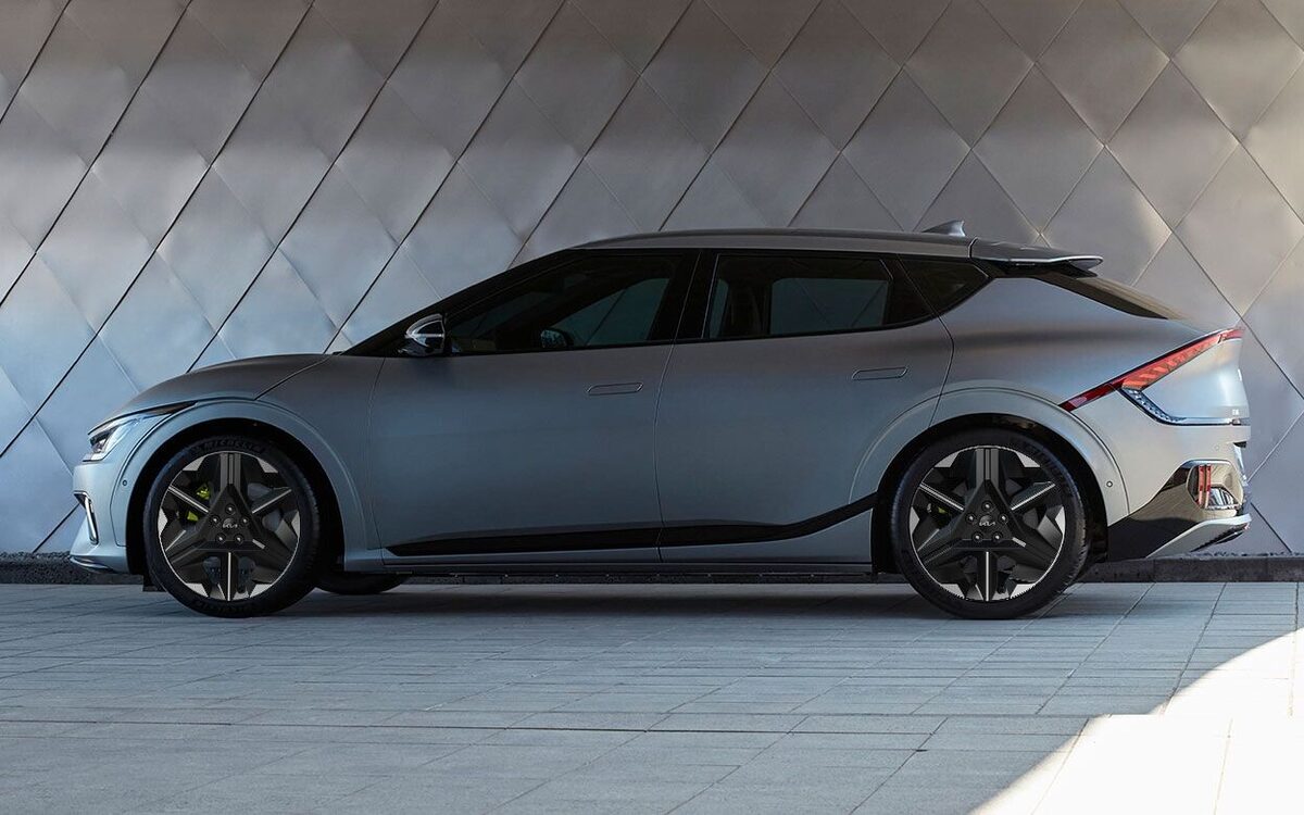 Kia EV6 in grey, side profile parked in front of a patterned metal wall