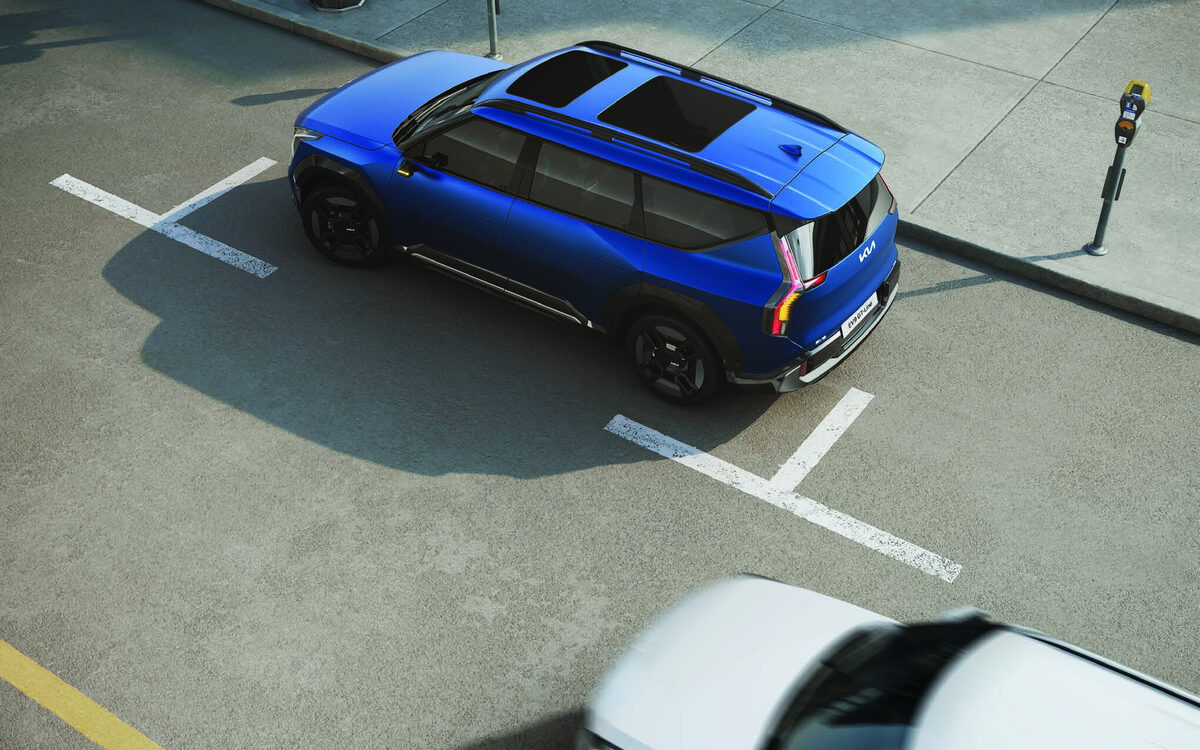 Kia EV9 in blue seen from above in a parking bay, showing the sunroof and roof rails