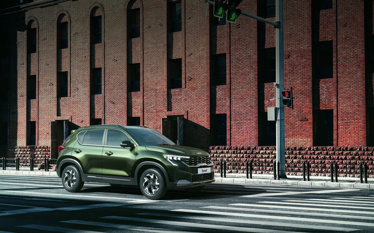 Kia Sonet in Pewter Olive parked on a city street in front of a brick building